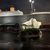 The image shows a large Titanic-themed building, resembling the iconic ship, with a mock iceberg in front, captured at night with a wet parking area reflecting the lights.