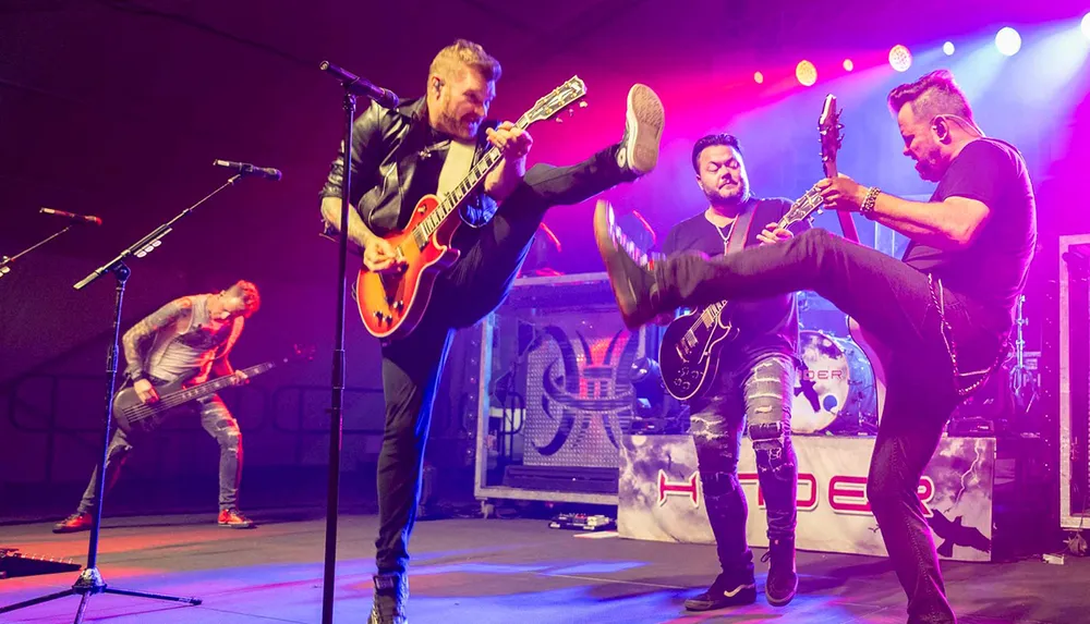 The image shows a dynamic scene with band members energetically playing electric guitars on stage with one member performing a high kick in the middle of a performance