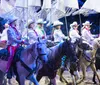 A performer in a blue costume is riding a white horse during a Christmas show at Dolly Partons Stampede Dinner Attraction