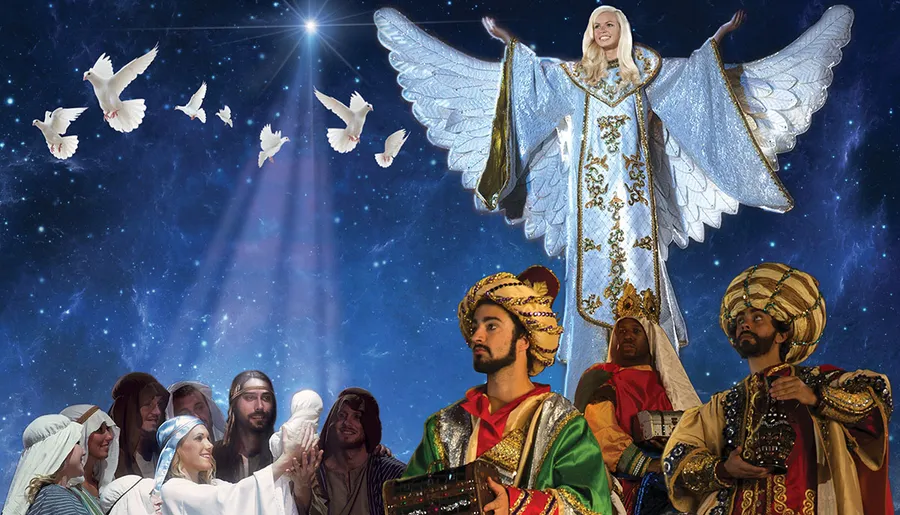 The image depicts a group of people dressed in biblical Nativity scene costumes, with a central figure portraying an angel, set against a starry night sky background with flying doves.